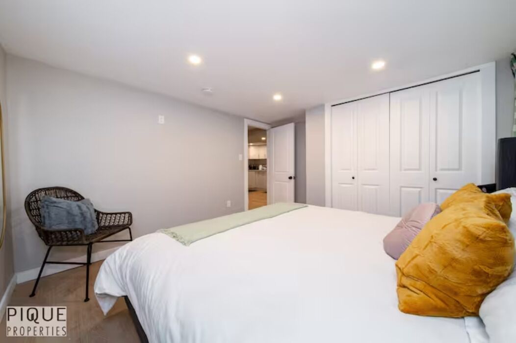 Een slaapkamer met een bed, een stoel en een kledingkast.