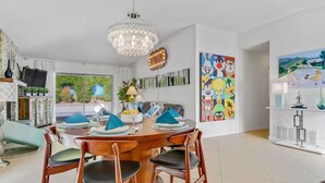 A modern dining area with a round wooden table, blue napkins, and wooden chairs.