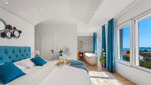 A modern bedroom with a large bed, a vanity, a bathtub, and a view of the sea. - Villa Lea with 4 bedrooms, 40sqm pool, Hot-Tub, 2km from the beach (Kastel Novi)