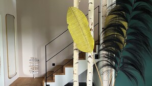 Eine moderne Treppe, gesäumt von Birken und einem großen Zierblatt.