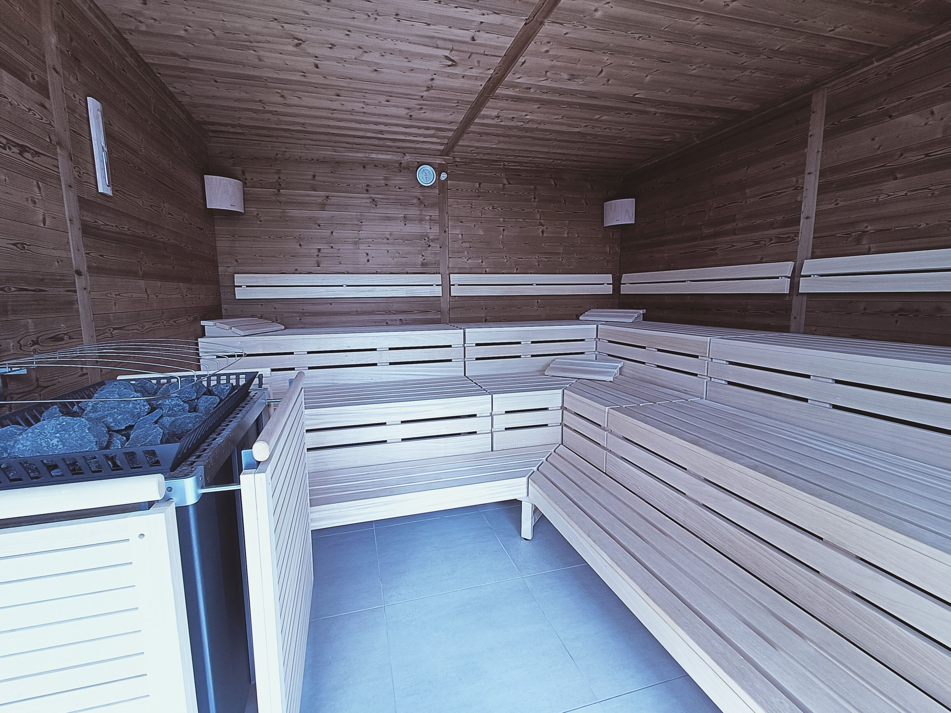 Ein Saunaraum mit Holzbänken und einem Saunatisch.