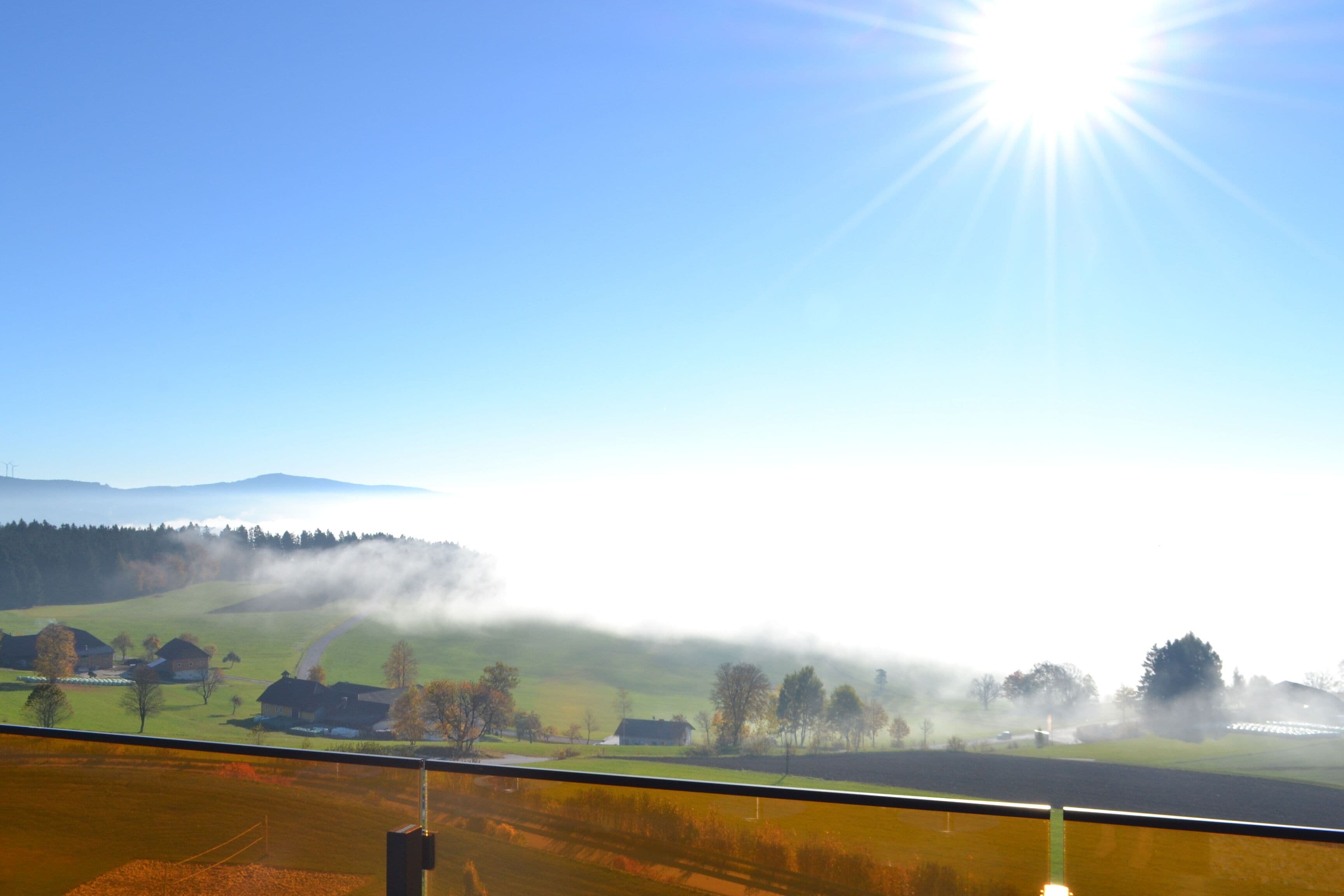 Ländliche Landschaft mit Häusern, Feldern und blauem Himmel.
