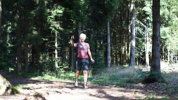 Une personne marchant sur un sentier de terre dans une zone boisée.