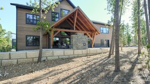 A modern two-story house with a stone foundation, wooden beams, and large windows. - Incredible Craftsman Style Spacious Lodge Walking Distance to Clubhouse! (Lead)