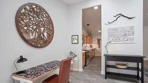 A dining area with a table, chair, and decorative wall art.