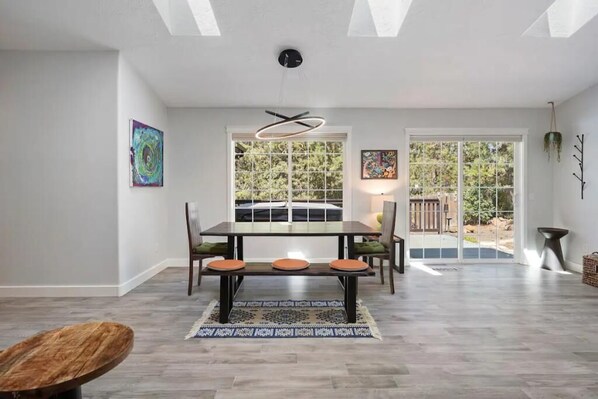 Un espace repas comprenant une table et des chaises, un tapis et des œuvres d’art accrochées aux murs.