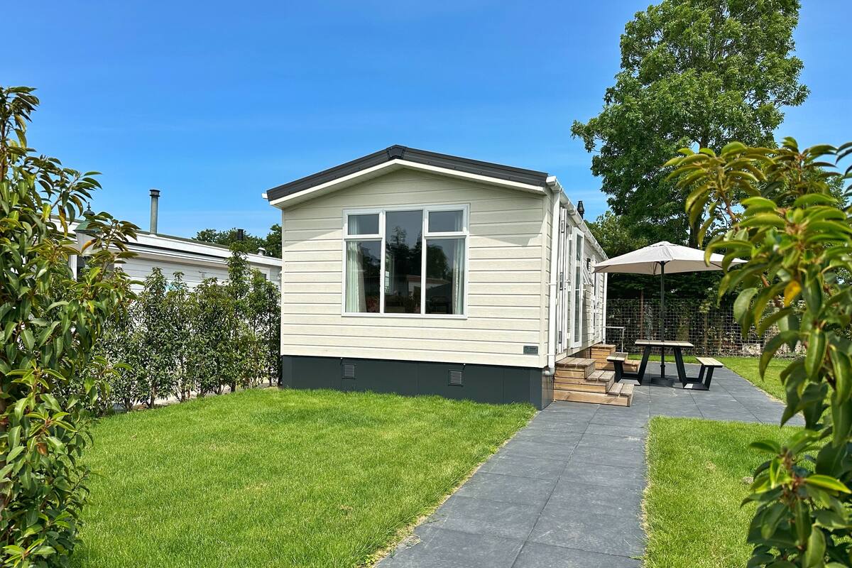 A single-story mobile home with a paved patio and a small deck area.