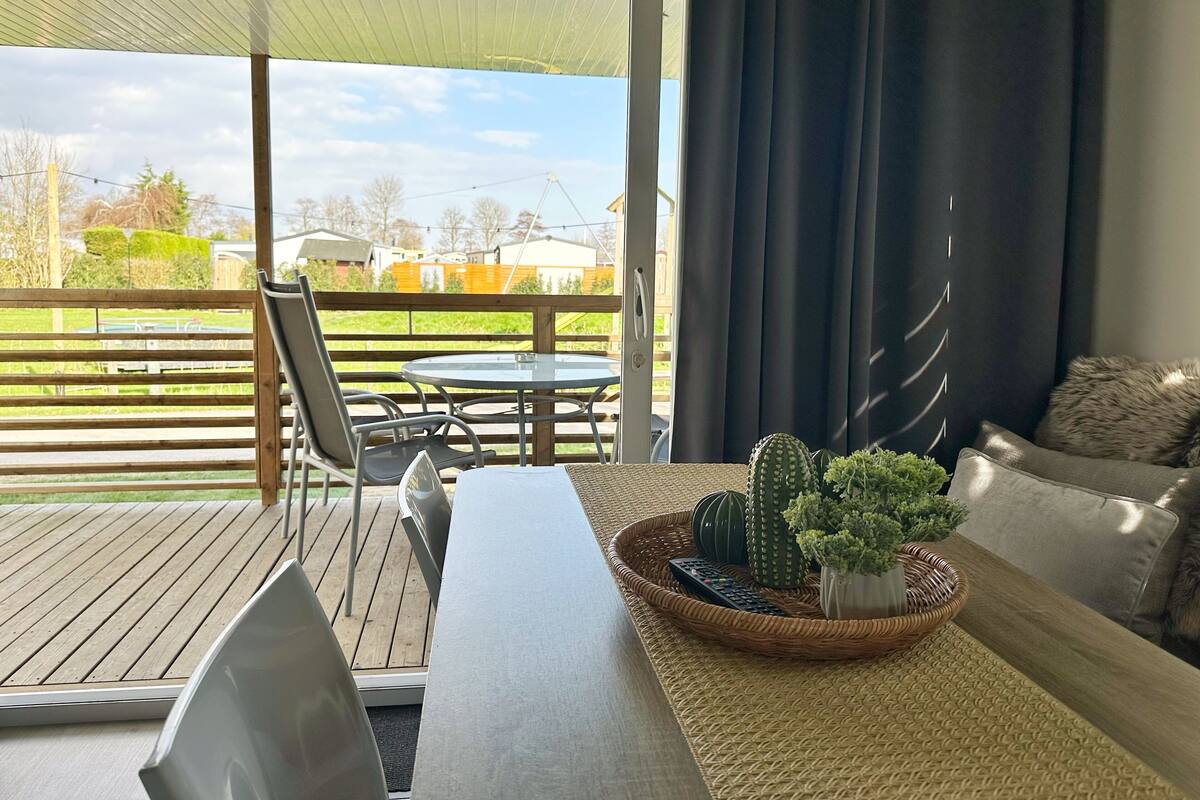 A covered patio area with a table, chairs, and a sofa.