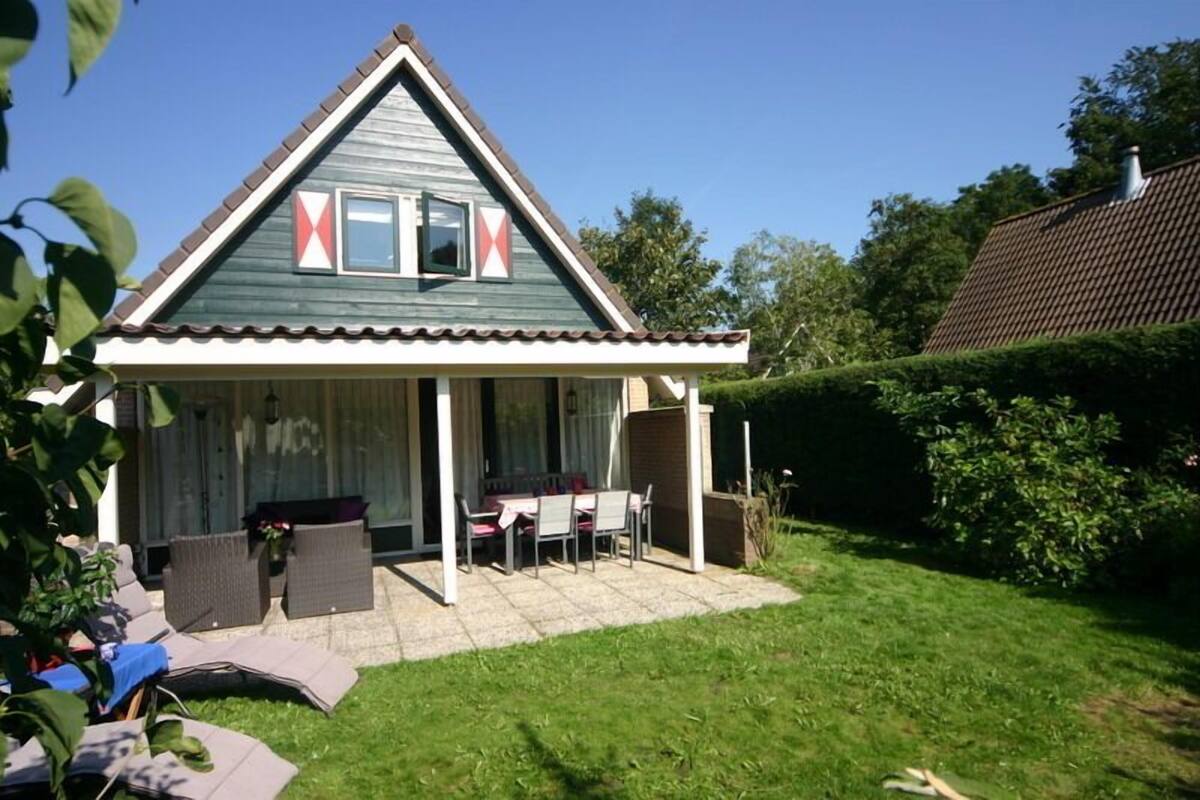A house with a covered patio, a dining area, and a small garden.