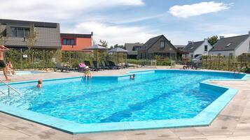 Alberca al aire libre por temporada y sombrillas en la alberca