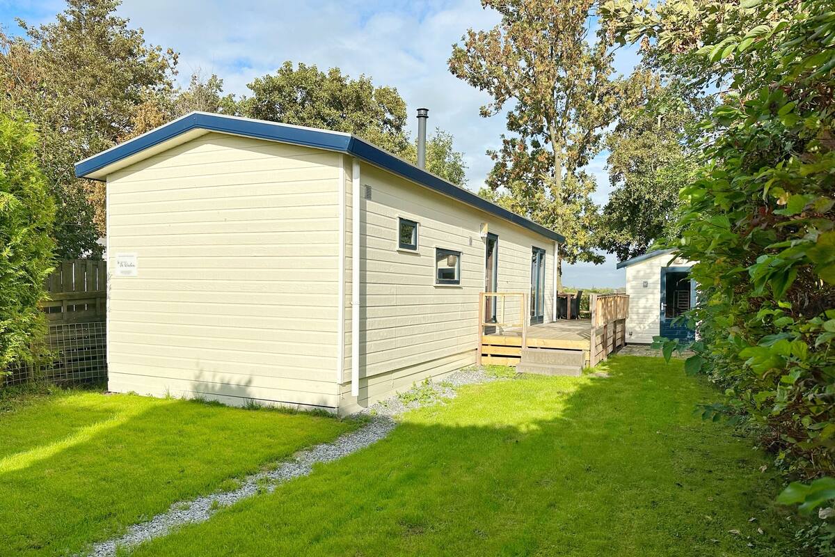 A small, single-story mobile home with a blue roof and a small porch.