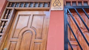 Una porta in legno con un cancello in metallo, un cartello sopra la porta e una finestra che dà sulla strada.