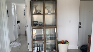 A spacious room with a large glass-fronted cabinet, a white door, and a tiled floor. - Beautiful Key Largo Bayside Condo! (Key Largo)