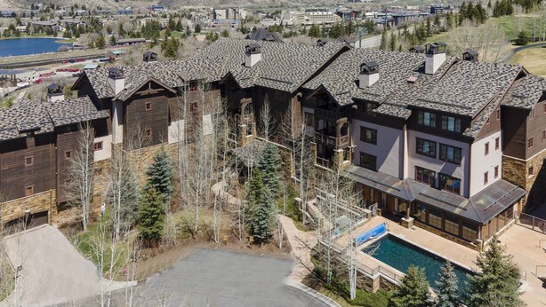 A resort with multiple chalet-style buildings, a swimming pool, and a view of the surrounding mountains. - Ski-in/out luxury condo. Best in the complex. Outdoor pool and hot tubs!! (Bachelor Gulch)