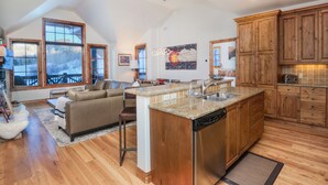 A spacious kitchen with wooden cabinets, a granite countertop, and a dishwasher. - Ski-in/out luxury condo. Best in the complex. Outdoor pool and hot tubs!! (Bachelor Gulch)
