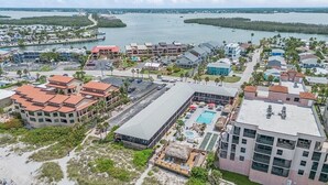 Vue aérienne d’un hôtel situé sur la côte, composé de plusieurs bâtiments, doté d’une piscine et offrant un accès direct à la plage.