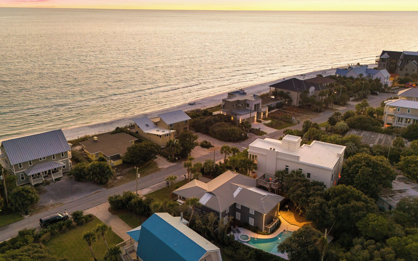 Zona residencial a la costa, amb cases, una piscina i una platja.