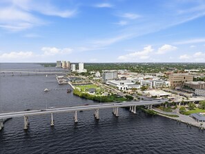 A coastal cityscape with a prominent bridge, waterfront buildings, and a marina. - Vibrant Bungalow in Historical Fort Myers District (Fort Myers)