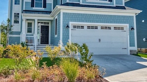 A two-story house with a garage, a front porch, and a well-maintained lawn. - Bayside * 4BR Luxury House (Selbyville)