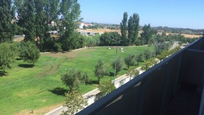 A view from a balcony overlooking a grassy area with trees and a clear sky. - 5 minutes to the theme park! Family-sized condo with game room & deck
  (Vila Nova da Baronia)