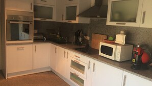 A kitchen with white cabinets, a microwave, a toaster, and a red coffee machine. - 5 minutes to the theme park! Family-sized condo with game room & deck
  (Vila Nova da Baronia)