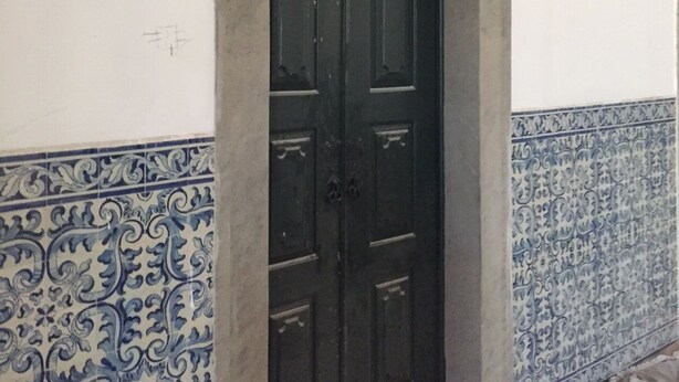 A dark wooden door with a decorative archway, set in a room with white walls and blue patterned tiles. - 5 minutes to the theme park! Family-sized condo with game room & deck
  (Vila Nova da Baronia)