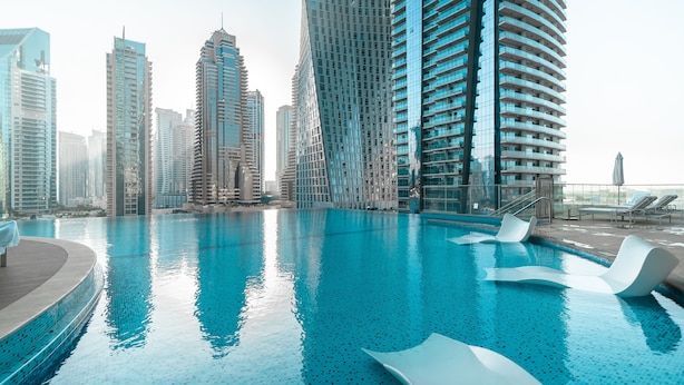 A swimming pool with modern architecture in the background. - Tranquil 2BR Haven in Heart Dubai Marina (Dubai)