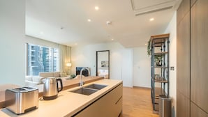 A modern kitchen with a built-in island, stainless steel appliances, and a view of the cityscape. - Tranquil 2BR Haven in Heart Dubai Marina (Dubai)