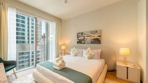 A hotel room with a large bed, a view of high-rise buildings, a painting on the wall, and a nightstand with a lamp. - Tranquil 2BR Haven in Heart Dubai Marina (Dubai)