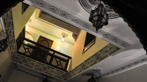 An ornate ceiling with intricate patterns and a balcony with lattice railings. - Riad Jibril (Marrakech)