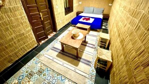 A small, cozy room with a bed, a wooden table, and a bench. - Riad Jibril (Marrakech)