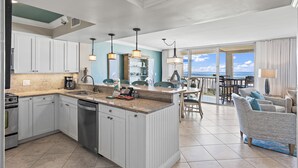 A modern kitchen with white cabinets, a central island, and pendant lighting. - 2BR Penthouse with Panoramic Views + Private Beaches | Magnolia House 602 (Destin)