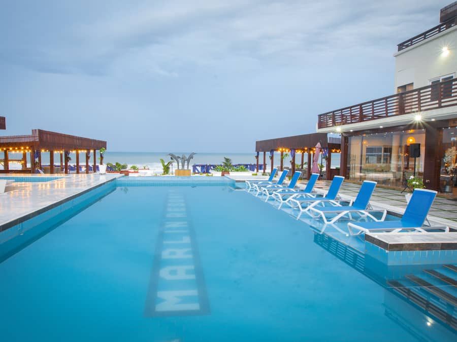 Una piscina con sillas de descanso y vistas al océano.