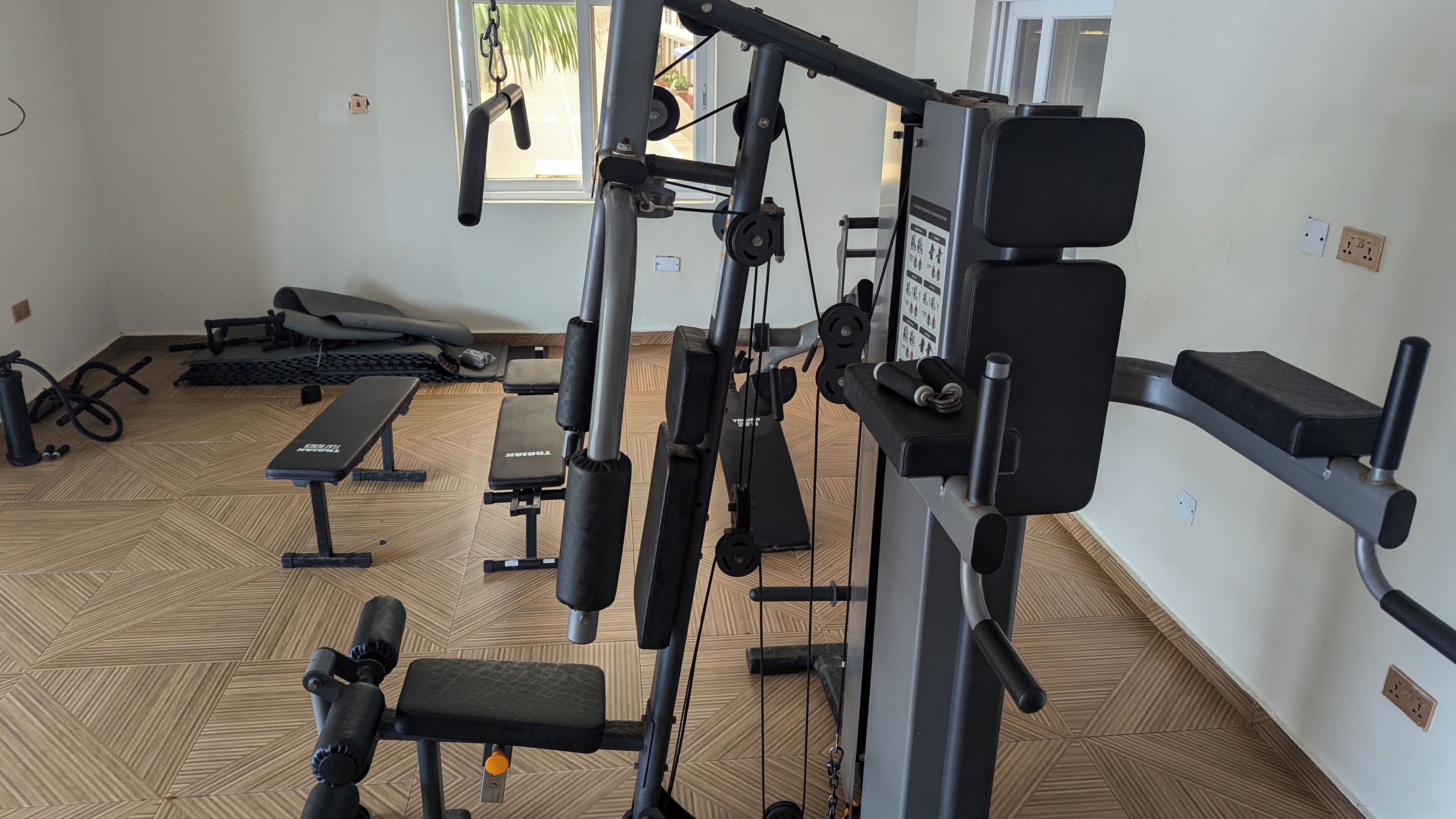 A gym with exercise equipment, benches, and a patterned floor.