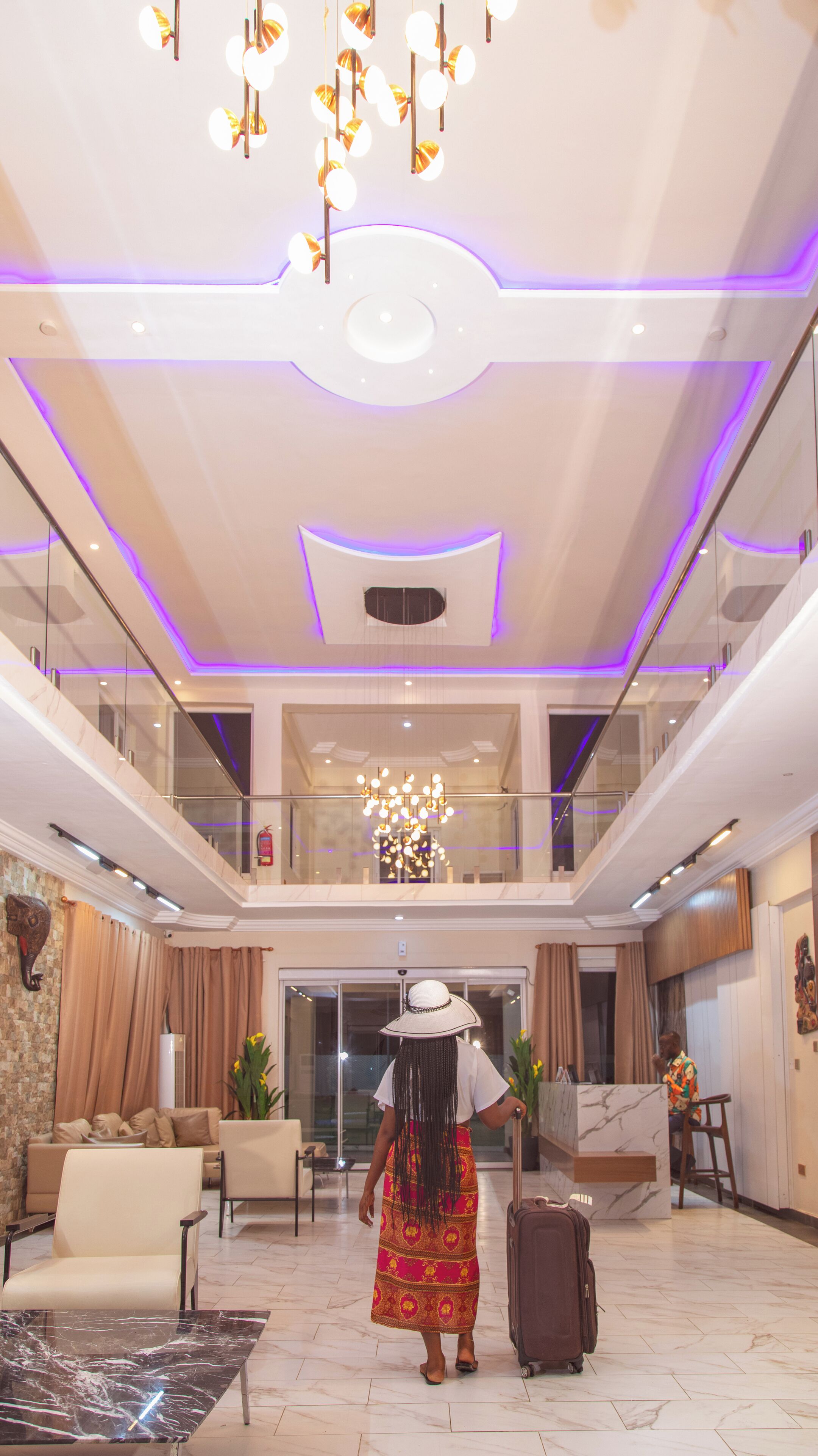 A spacious lobby with a high ceiling, a chandelier, and a modern design.