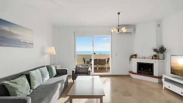 Un salon moderne avec un canapé, une table basse, une cheminée et un téléviseur.