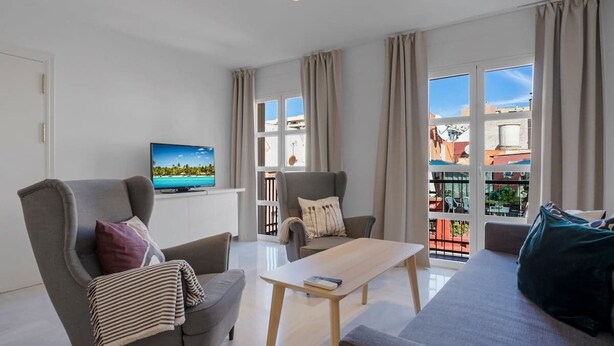 Ein modernes Wohnzimmer mit einer Couch, einem Sessel und einem Couchtisch.