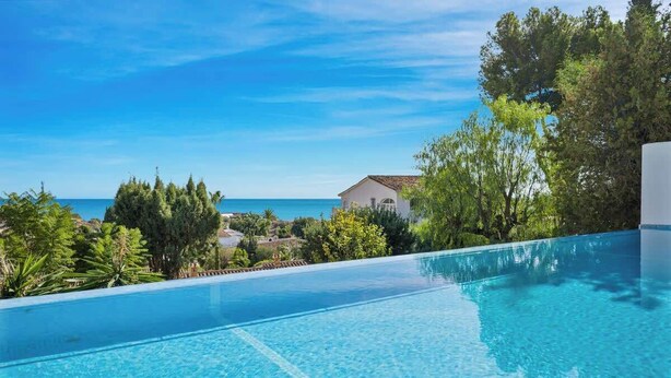 A clear blue swimming pool with a view of the sea and a building in the background. - Benalmadena over the sea by Costarentals - Ref 17 (Benalmádena)