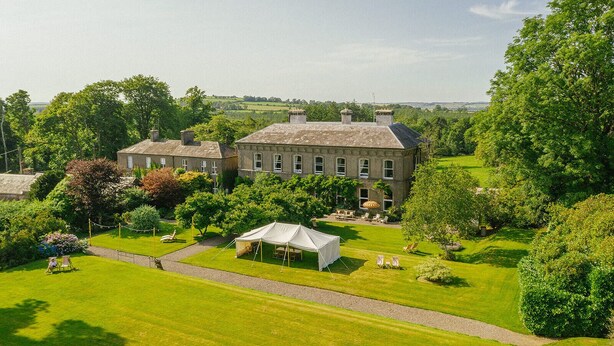 A large estate with a main building, a lawn, and a tent set up for outdoor activities. - Ballyvolane House (Kilcor)
