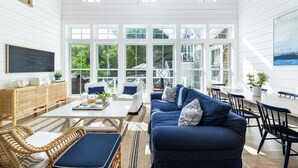 Un salon spacieux avec un grand canapé, une table basse et un coin repas équipé de chaises.