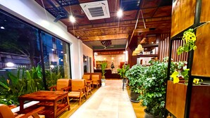 A modern indoor space with wooden furniture, potted plants, and a reception area. - Le Vert Angkor Hotel  (Siem Reap)