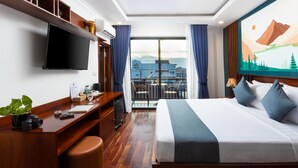 A hotel room with a bed, desk, television, and a balcony with a city view. - Le Vert Angkor Hotel  (Siem Reap)