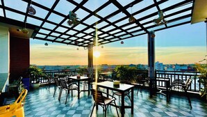 A rooftop terrace with checkered flooring, tables, chairs, and hanging lights. - Le Vert Angkor Hotel  (Siem Reap)