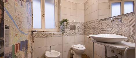 A bathroom with a bidet, toilet, and sink.