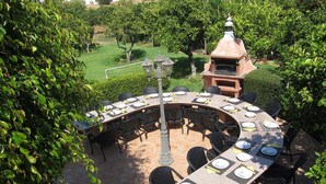 A round outdoor dining area with a brick barbecue and a pergola. - Casa da Horta, 1 bedroom apartment, CH1, Pool and Garden (Albufeira)