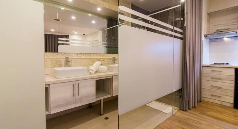 Une salle de bain moderne avec un grand miroir, une baignoire et un espace douche.