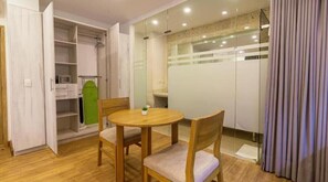 A room with a wooden dining table and chairs, a white wardrobe, and a glass shower enclosure. - Hermoso Manga 1br/cerca de Getsemaní 105 (Cartagena de Indias)