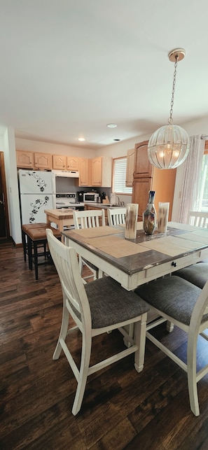 A spacious kitchen with wooden cabinets, a dining table with chairs, and a hanging light fixture. - Increíble Loft Dúplex Cerca de Old City /getsemaní 101 (Cartagena de Indias)
