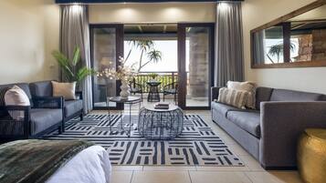 Un salon moderne avec un canapé, une table basse et un balcon offrant une vue agréable.