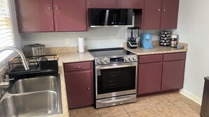 Una cocina con electrodomésticos de acero inoxidable, microondas, cafetera y tostadora.